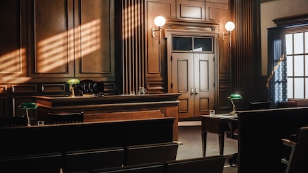 Empty courtroom interior with judge’s bench and warm lighting.